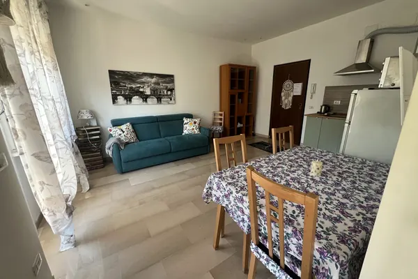 Bright open-plan living room with kitchenette and sofa bed, Il Pianoforte apartment in Monteverde, Rome