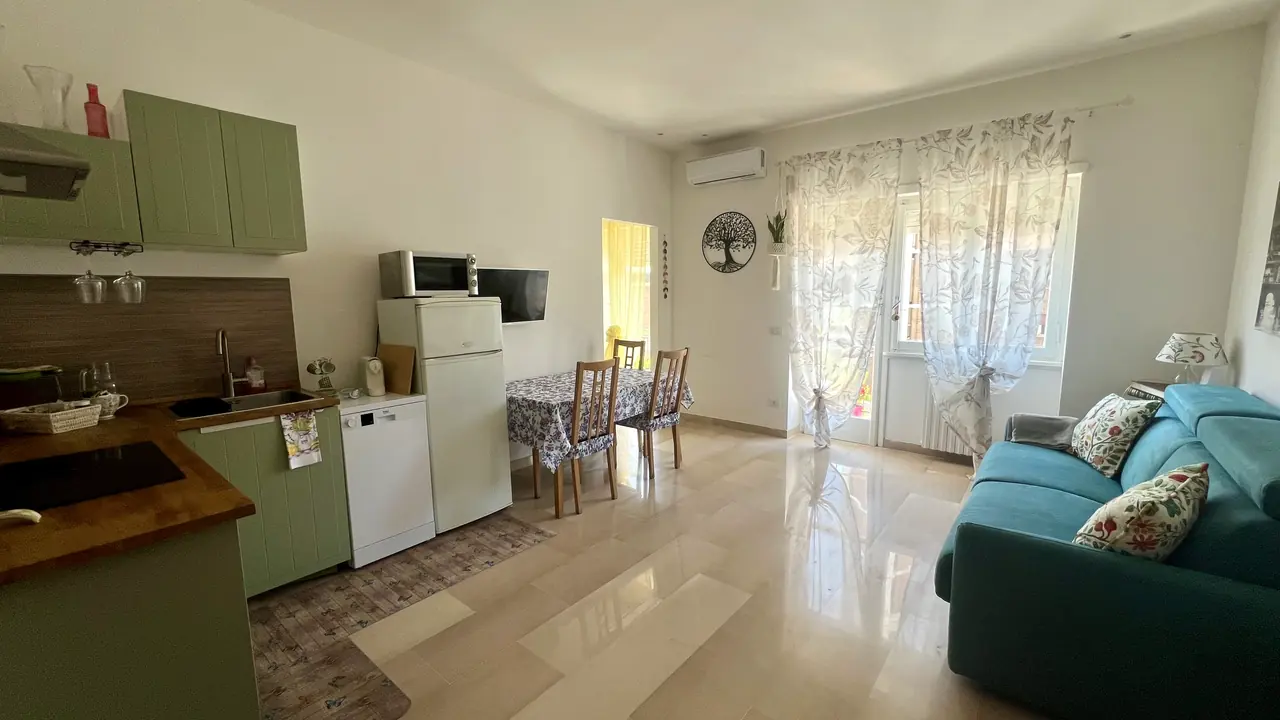 Bright open-plan living room with kitchenette and sofa bed, Il Pianoforte apartment in Monteverde, Rome